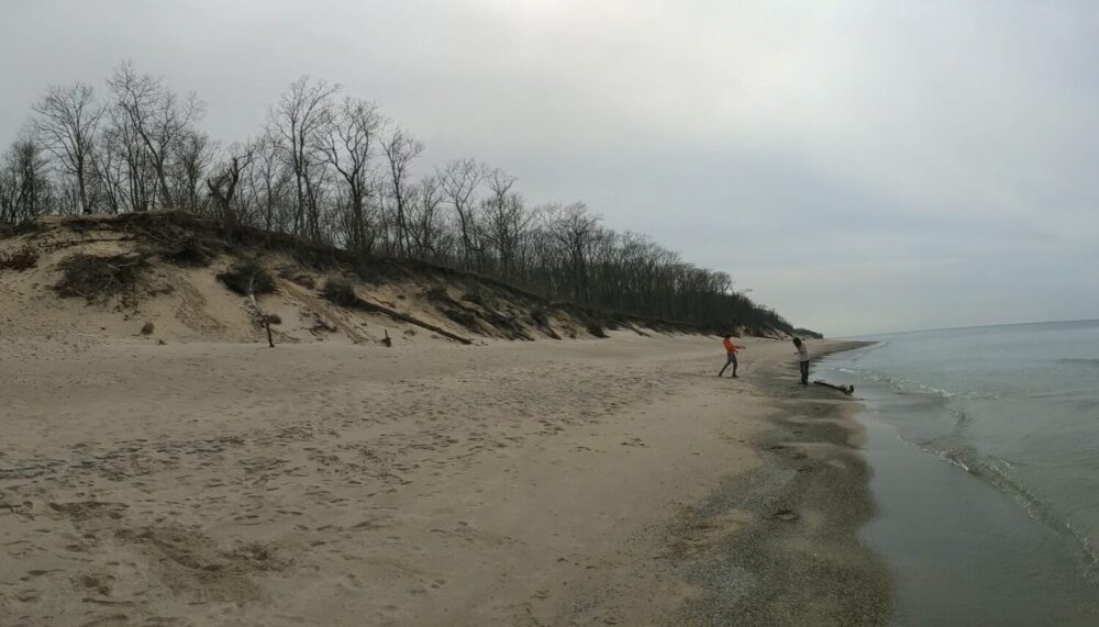Walking along the beach of Lake Michigan with sand dunes in the background
